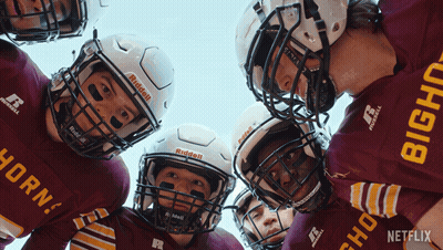 A Group Of Football Players Are Huddled Together With One Wearing A Red Jersey That Says Horn GIF
