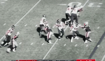 A Group Of Football Players Are On A Field Playing A Game Of Football . GIF
