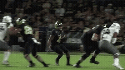 A Group Of Football Players Are Playing A Game Of Football . GIF