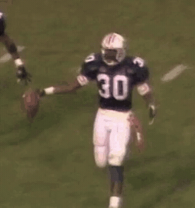 A Group Of Football Players Are Playing A Game Of Football . GIF