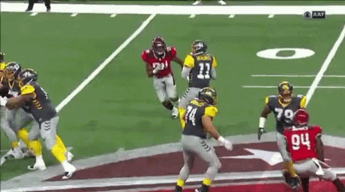 A Group Of Football Players Are Playing A Game On A Field . One Player Has The Number 14 On His Jersey . GIF
