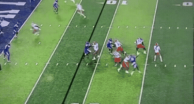 A Group Of Football Players Are Playing A Game On A Green Field . GIF