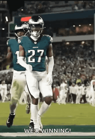 A Group Of Football Players Are Running On A Field And One Of Them Has The Number 27 On His Jersey . GIF