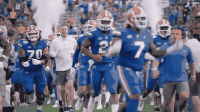 A Group Of Football Players Are Running On A Field And One Of Them Has The Number 7 On His Jersey GIF