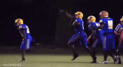 A Group Of Football Players Are Running On A Field With The Words Shot By Blake Visible In The Corner GIF