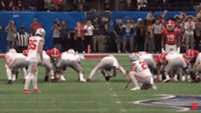A Group Of Football Players Are Squatting On The Field . One Of The Players Has The Number 55 On His Jersey . GIF