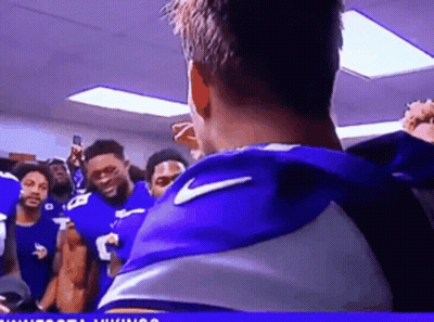 A Group Of Football Players Are Standing In A Locker Room GIF