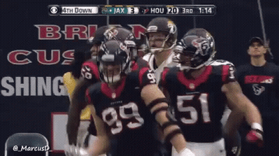 A Group Of Football Players Are Standing In Front Of A Sign That Says ' Brig Cus Shing ' GIF