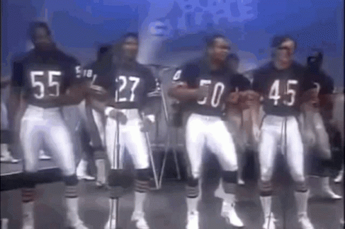 A Group Of Football Players Are Standing Next To Each Other In A Line . GIF