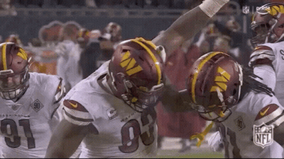 A Group Of Football Players Are Standing Next To Each Other On The Field . GIF