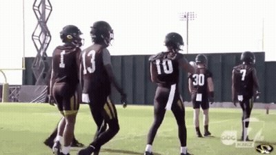 A Group Of Football Players Are Standing On A Field And One Has The Number 30 On His Back . GIF