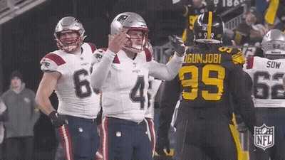 A Group Of Football Players Are Standing On A Field And One Of Them Is Wearing A Jersey With The Number 39 On It . GIF