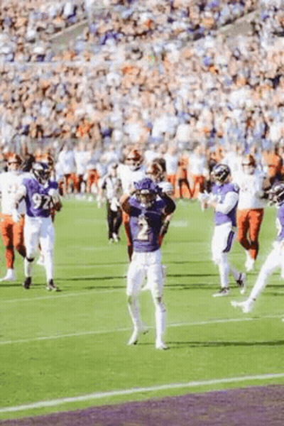 A Group Of Football Players Are Standing On A Field During A Game . GIF
