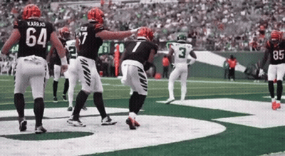 A Group Of Football Players Are Standing On A Field . One Of The Players Has The Number 7 On His Jersey . GIF