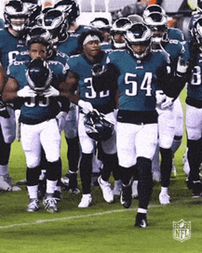 A Group Of Football Players Are Walking On A Field With The Number 54 On Their Jersey GIF
