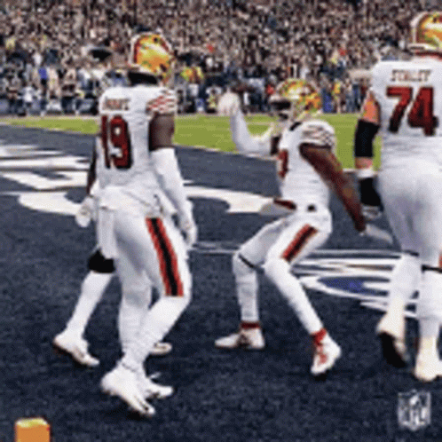 A Group Of Football Players Are Walking On The Field And One Has The Number 19 On His Jersey GIF