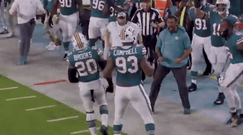 A Group Of Football Players Including Campbell And Brooks Are On A Field GIF