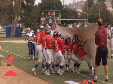 A Group Of Football Players On A Field With A Scoreboard In The Background That Says 80:00 GIF