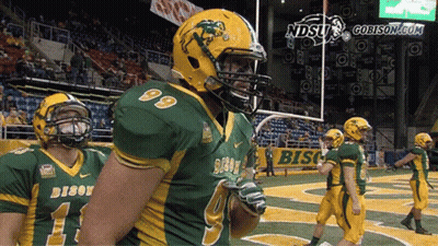 A Group Of Football Players Wearing Green And Yellow Uniforms With The Word Bison On Them GIF