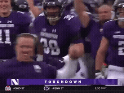 A Group Of Football Players Wearing Purple Uniforms Are Celebrating A Touchdown Against Penn State GIF