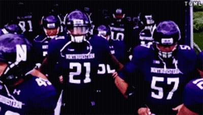 A Group Of Football Players Wearing Purple Uniforms With The Number 52 GIF