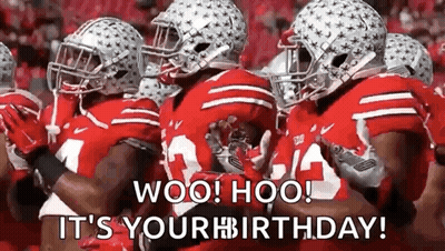 A Group Of Football Players Wearing Red Uniforms And Helmets Are Standing Next To Each Other On A Field . GIF