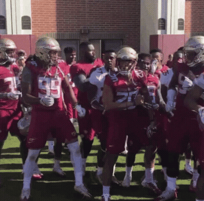 A Group Of Football Players Wearing Red Uniforms With The Number 29 On Them GIF