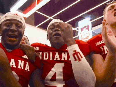 A Group Of Football Players Wearing Red Uniforms With The Number 4 On Them GIF