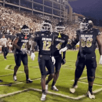 A Group Of Football Players Wearing Uniforms That Say Colorado Are Running On The Field GIF