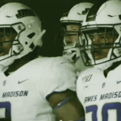 A Group Of Football Players Wearing White Uniforms With The Word Madison On The Front GIF