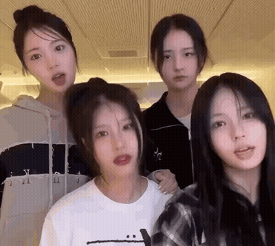A Group Of Four Girls Are Standing Next To Each Other In A Room . GIF