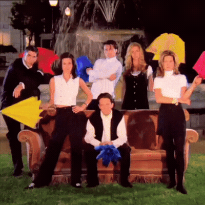 A Group Of Friends Posing For A Picture With Umbrellas In Front Of A Fountain GIF
