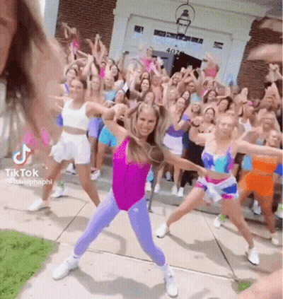 A Group Of Girls Are Dancing In Front Of A Building . GIF