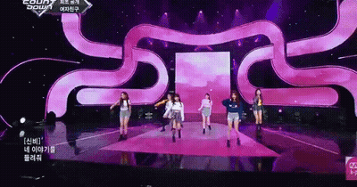 A Group Of Girls Are Dancing On A Stage With A Purple Background GIF