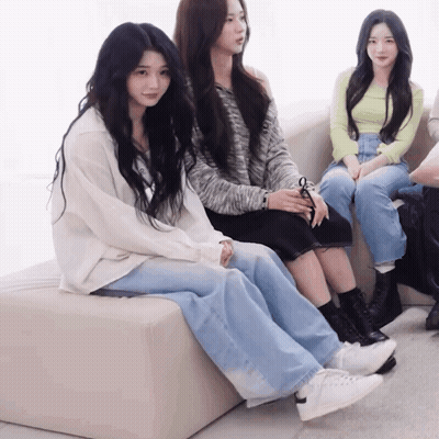 A Group Of Girls Are Sitting On A Couch With One Wearing A White Shirt GIF
