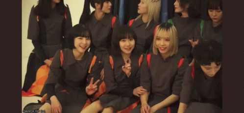 A Group Of Girls Are Sitting Together And One Of Them Is Covering Her Mouth GIF