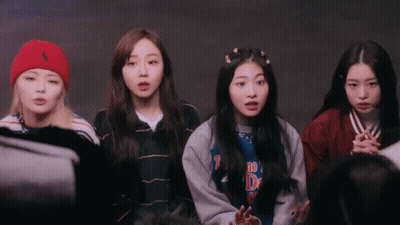 A Group Of Girls Are Standing In A Circle And One Of Them Is Wearing A Shirt That Says ' The D ' On It GIF