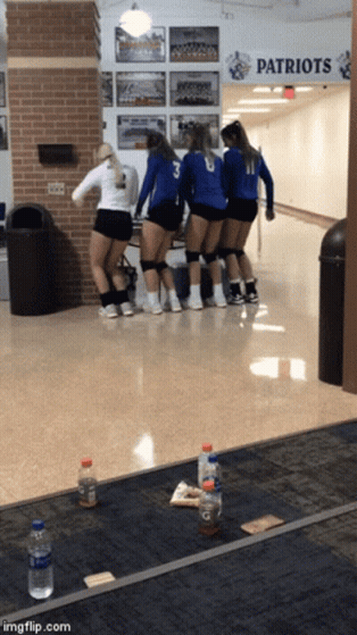 A Group Of Girls Are Standing In A Hallway Under A Patriots Sign GIF