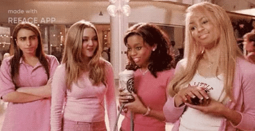 A Group Of Girls In Pink Outfits Are Standing Next To Each Other In A Mall . GIF