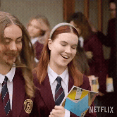 A Group Of Girls In School Uniforms Are Walking Down A Hallway And Smiling . GIF