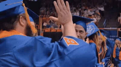 A Group Of Graduates Are Giving Each Other A High Five . GIF