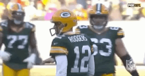 A Group Of Green Bay Packers Players Are Standing Next To Each Other On The Field . GIF