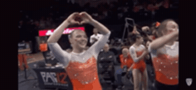 A Group Of Gymnasts Are Making A Heart With Their Hands . GIF