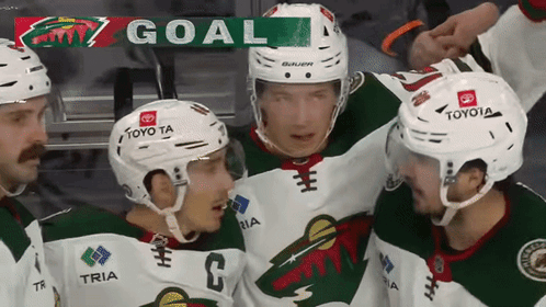 A Group Of Hockey Players Are Celebrating A Goal With A Banner That Says Goal GIF