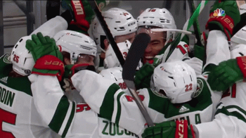 A Group Of Hockey Players Are Hugging Each Other And One Of The Players Has The Number 23 On His Jersey GIF
