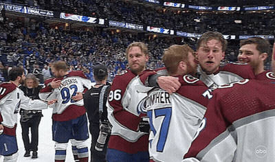 A Group Of Hockey Players Are Hugging Each Other Including Number 7 GIF