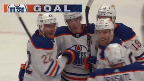 A Group Of Hockey Players Celebrate A Goal With A Banner That Says Goal GIF