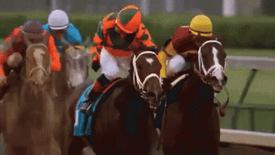 A Group Of Horses And Jockeys Are Racing On A Track . GIF