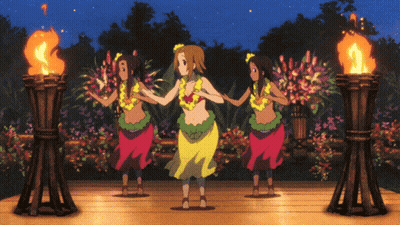 A Group Of Hula Dancers Are Dancing In Front Of Flaming Torches GIF