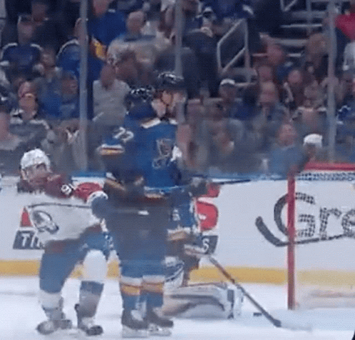 A Group Of Ice Hockey Players Are Playing A Game On The Ice . GIF